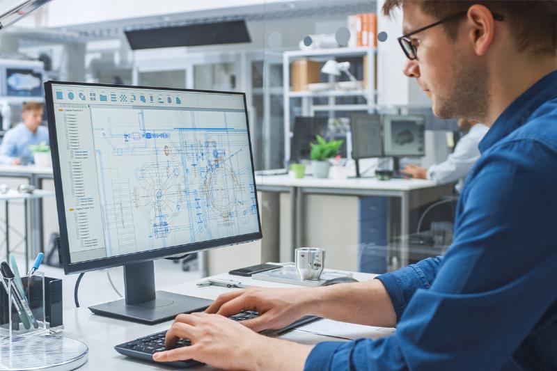 Équipe d’une agence d’architecture à Marseille travaillant sur un projet avec des plans et des ordinateurs